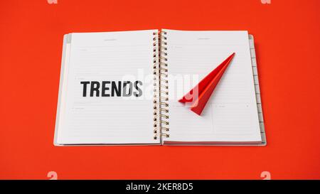 Global World Trends, Top New trends, forecasting. Word trends and red paper plane on red background. Stock Photo