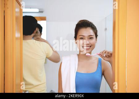 Beautiful young Asina woman brushing her teeth in the morning Stock Photo