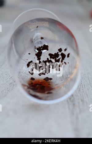 Glass of white wine with grapes and dried up vine leaves. Old wooden ...