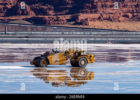 A heavy-duty scraper harvesting potash from an evaporation pond at a potash mine  near Moab, Utah. Stock Photo