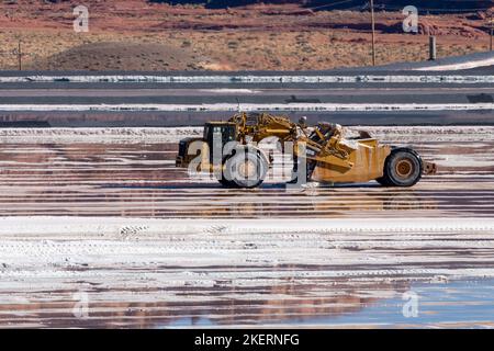 A heavy-duty scraper harvesting potash from an evaporation pond at a potash mine  near Moab, Utah. Stock Photo