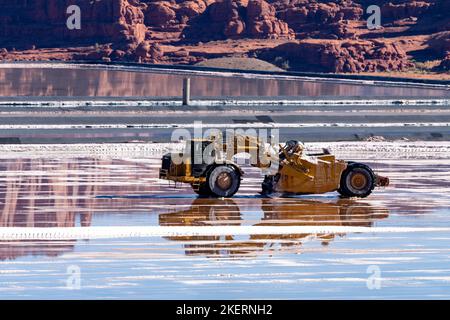 A heavy-duty scraper harvesting potash from an evaporation pond at a potash mine  near Moab, Utah. Stock Photo