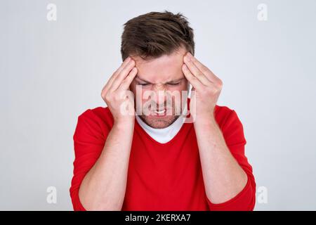 man experiencing headache, pressing fingers to temples trying to ease pain  Stock Photo