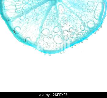 Juicy lime slices with bubbles under water isolated on white background. Light blue lemon slices pattern textured background. Stock Photo