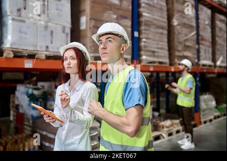 Team of warehouse employees performing a racking system inspection Stock Photo