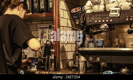 Epsom Surrey, London UK, November 14 2022, Young Woman Barista Making Coffee In A High Street Cafe Nero Coffe Shop Stock Photo