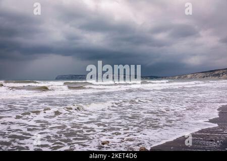 Surfing in the stormy waters at high tide at Compton Bay Isle of Wight south east England Stock Photo