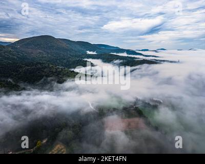 Thick morning fog covering the valley between the surrounding mountains in southern France, autumn season Stock Photo