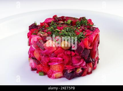 Vinaigrette. Traditional russian beetroot salad with boiled vegetables, pickled cucumbers, sour cabbage, olive oil and green canned peas. Vegetarian h Stock Photo