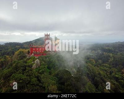 Aerial drone view of Park and National Palace of Pena in Sintra, Portugal during a foggy day. Unesco. Historic visits. Sightseeing. Fairytale. Stock Photo