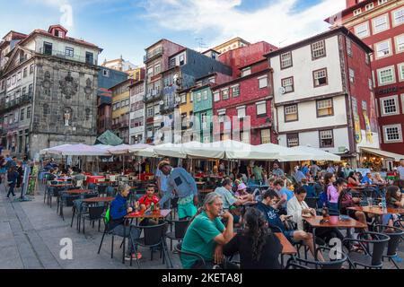 Porto, Portugal - July 26th, 2018 : People sit at an outdoors cafe in the Unesco World Heritage–listed Ribeira district. Stock Photo