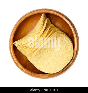 Stackable salted potato chips, in a wooden bowl. Thin slices of American potato-based crisps, with a content of 42 percent potatoes. Stock Photo