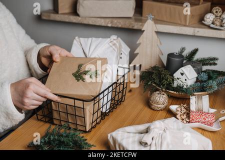 Holiday budget. Christmas Cheap budget-friendly gifts ideas. Xmas holiday homemade gift for everyone. Woman wrapping Christmas DIY gifts in craft Stock Photo