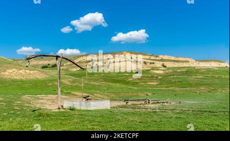 Water well and rusty bucket from the Transylvanian hills in Romania. Stock Photo