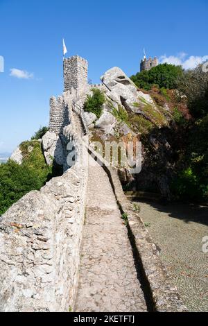 The fortified walls and turrets of the 10th century Moorish Castle of the Moors (Castelo dos Mouros) above Sintra, Portugal. Stock Photo