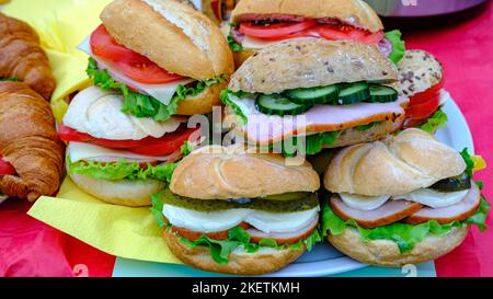 Lots of homemade burgers, fresh stuffing for cucumbers on a whole wheat artisan bun on the kitchen table for dinner Stock Photo