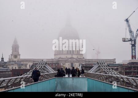 London, UK. 14th November 2022. People walk along Millennium Bridge towards a partially obscured St Paul's Cathedral as thick fog covers the capital. Credit: Vuk Valcic/Alamy Live News Stock Photo