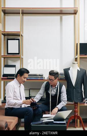 Vietnamese male fashion designers discussing material for the new collection Stock Photo