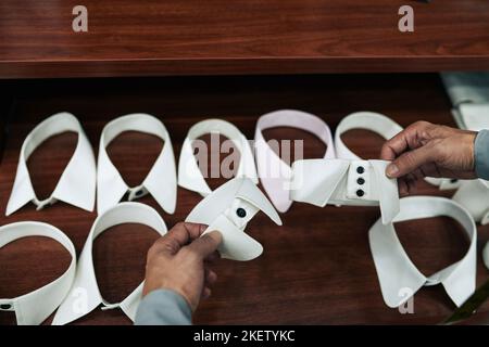 Customer choosing type of collar for his shirt in atelier Stock Photo