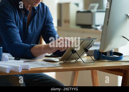 Cropped image of architect checking data on tablet computer Stock Photo