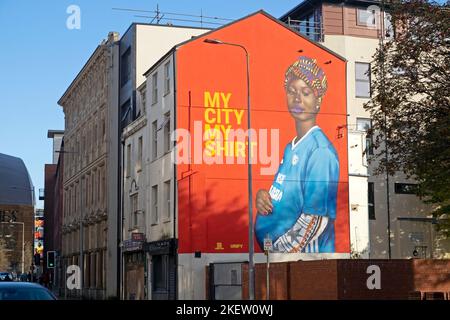 'My City My Shirt' mural pregnant African Welsh woman wearing football shirt jersey Butetown Cardiff Bay area Wales UK  Great Britain KATHY DEWITT Stock Photo