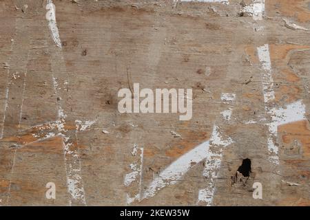 Weathered wood background with chipped white paint lines and hole. Stock Photo