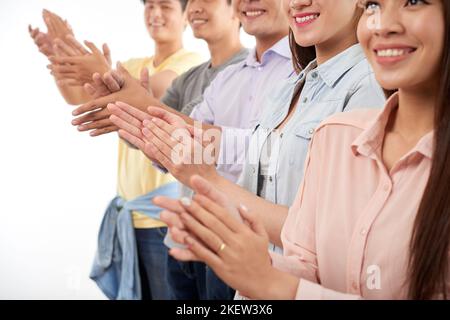 Cropped image of applauding smiling yuong people Stock Photo