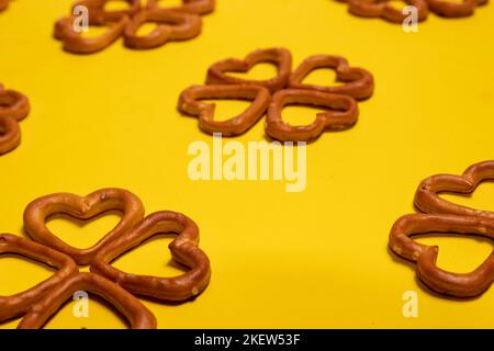 Heart-shaped salty pretzels on yellow background Stock Photo