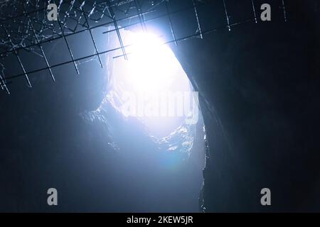 Rock cave with hole through which light shines. Underworlds in Sweden. Mystical atmosphere. Nature shot from Scandinavia Stock Photo