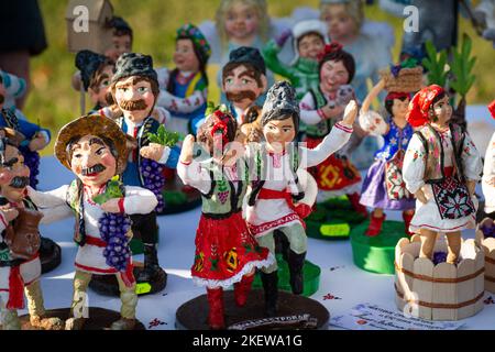 Assortment of clay Souvenirs. Clay souvenir figurines of mans and womens with wines and grape. Souvenir figurines of Moldavians. Moldavian folk art on Stock Photo