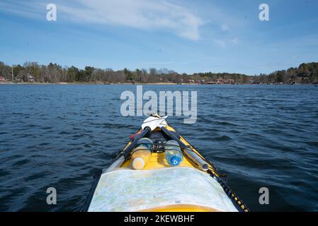 The view on board a yellow sea kayak, paddling through the islands of the Swedish Stockholm Archipelago, Sweden. Stock Photo