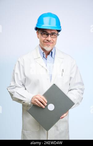 Middle age engineer in lab coat and hard hat. Scientist, architect with tablet. Mid adult, mature age man, happy smiling. Portrait isolated on white. Stock Photo