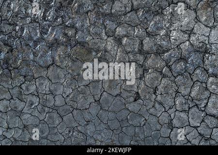 Black cracked texture of jet black surface of charcoal or soot close up. Black land texture and background Stock Photo