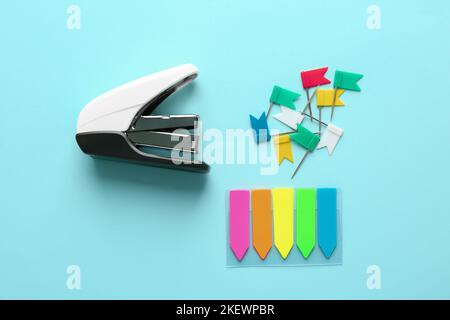 Office stapler, sticky notes and pins on color background Stock Photo