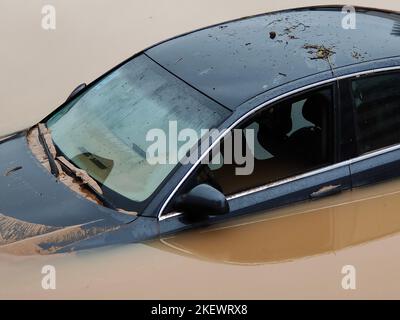 Torrential rain causes flash floods in the city area. Cars under water in the condominium parking lot. Damaged cars caused by heavy rainfall. Stock Photo