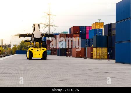 Forklift handling cargo container. Freight container loading. Container handler.  Logistics import export concept. Industrial container logistic yard. Stock Photo