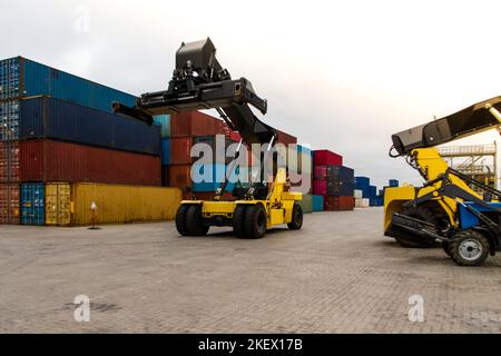 Forklift handling cargo container. Freight container loading. Container handler.  Logistics import export concept. Industrial container logistic yard. Stock Photo