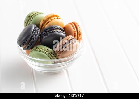 Sweet macaron dessert. Colorful macarons in bowl on the white table. Stock Photo