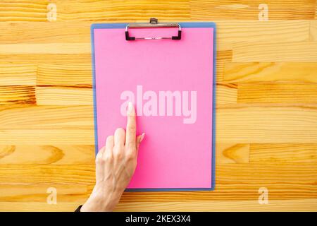 Blank Folder with Yellow Paper. Hand that Holding Folder and Handle on Wood Background. Copyspace. Place for Text. Stock Photo