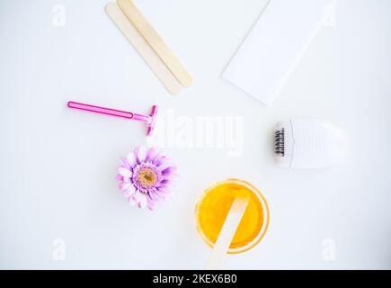 Waxing. Set for Epilation Of different Means For Epilation on a White Background. Removal of Unwanted Hair. Modern Epilator, Wax Strips, Razor Stock Photo