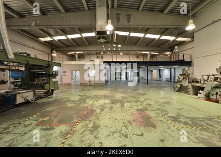 A warehouse of an industrial building machinery without working, various rooms and with polished concrete floors and ceilings with skylights Stock Photo