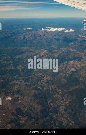 Scenic mountain view from an airplane window while flying across the countryside Stock Photo