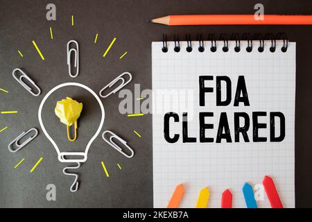 'FDA cleared' words on wooden blocks. Business concept. Beautiful white and blue background Stock Photo