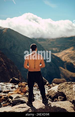 Boy looking at an impressive mountain landscape from the top Stock Photo