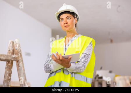 Female civil engineer making notes at construction site Stock Photo