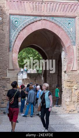 People in an Islamic arch gate to the Alhambra, Granada, Andalusia, Spain Stock Photo