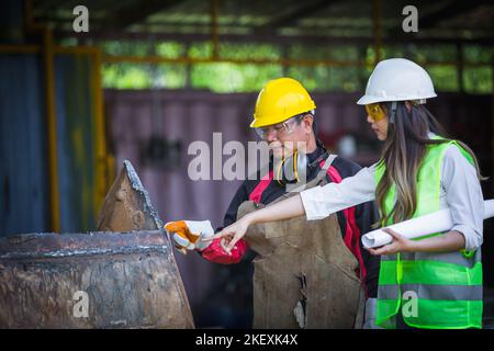 Asian female engineer checks workers' welds Stock Photo