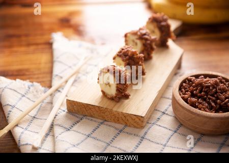 Banana sushi sweet rolls with caramel, peanut butter and chocolate puffed rice. Funny and easy homemade snack for kids and adults. Stock Photo