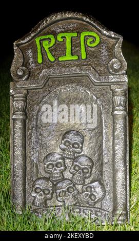 Halloween Rest in Peace Tombstone with Head Skulls Decorating Yard at Night Stock Photo