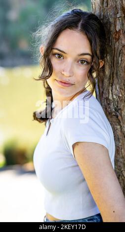 Close Up of Beautiful Teen Girl Leaning Against in Tree Overlooking a Lake Stock Photo